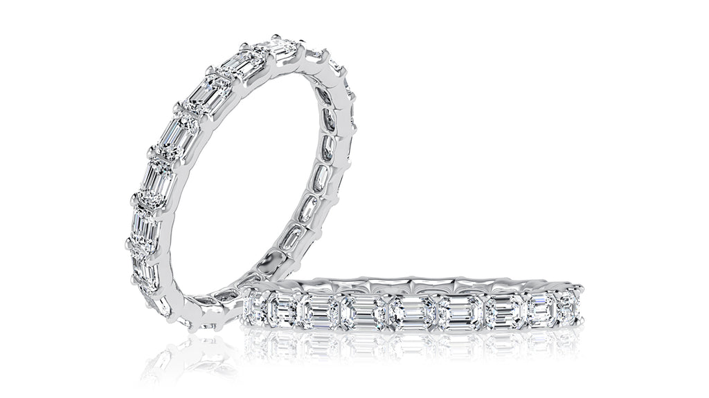 East-west emerald cut diamond band in white gold.