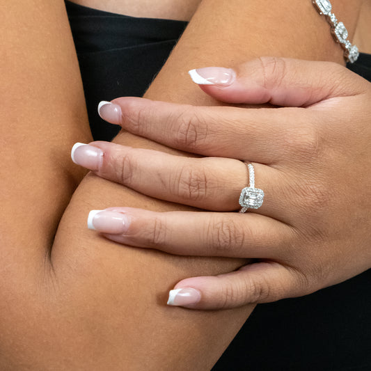 White gold diamond halo ring on hand.
