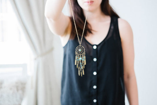 Turquoise dreamcatcher necklace with silver feathers.
