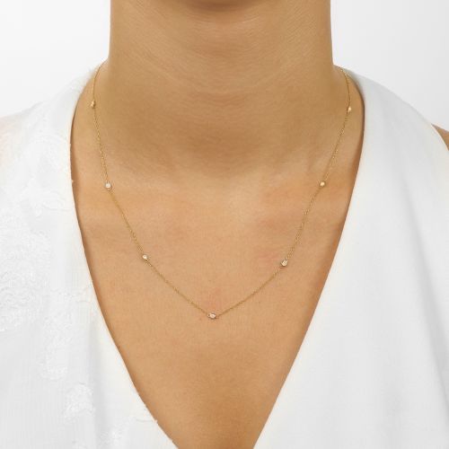 Bezel set diamond necklace in yellow gold.