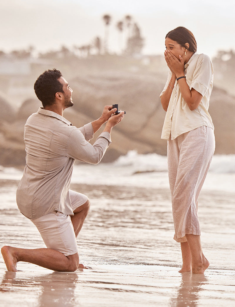 man proposing to woman on beach
